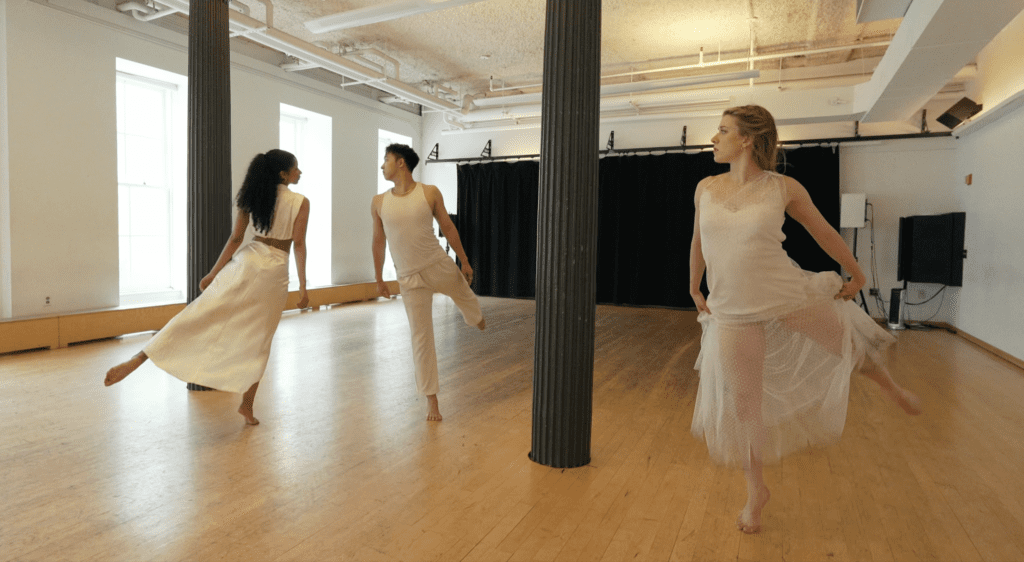 A still from the video Pastel Feelings. Three dancers in white pique in a dance studio.